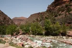 Rocky Ourika canyon with a mountain stream cutting through red-brown hills