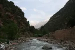 Riverside café terrace in the Ourika gorge, rock walls and a snow-capped peak in view