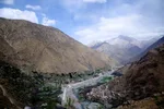 Panoramic view of the Ourika Valley, with a village on the riverbed below a snow-capped High Atlas peak