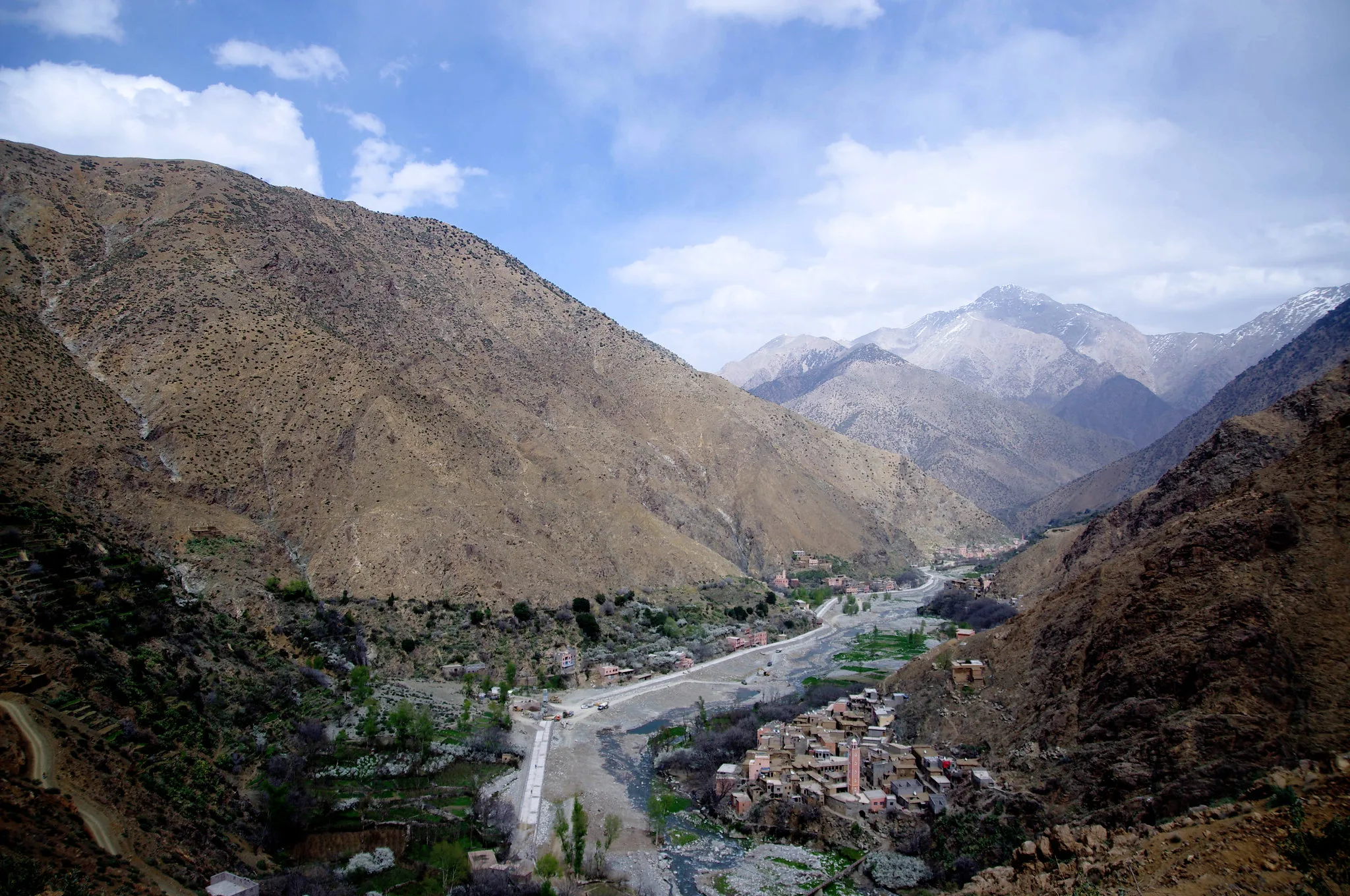 Panoramic view of the Ourika Valley, with a village on the riverbed below a snow-capped High Atlas peak Panoramic view of the Ourika Valley, with a village on the riverbed below a snow-capped High Atlas peak