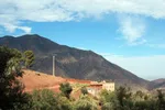 Traditional Berber farmhouse on a red hillside in the Asni Valley
