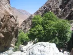 Rocky gorge in the Ourika Valley, with a visitor resting on the boulders beside a mountain stream