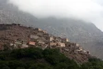 Village on a hillside near Imlil beneath low cloud partly obscuring the mountain above